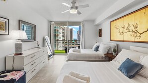 Ein modernes Hotelzimmer mit Bett, Nachttisch, Lampe und Kunstwerk.