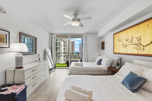 Una habitación de hotel moderna con cama, mesita de noche, lámpara y obra de arte.