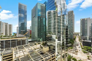 Zona urbana con edificios modernos, un estacionamiento y cielo despejado.