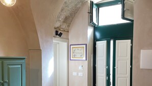 Ein Zimmer mit Tisch, Stühlen und einer Tür zu einem anderen Raum.