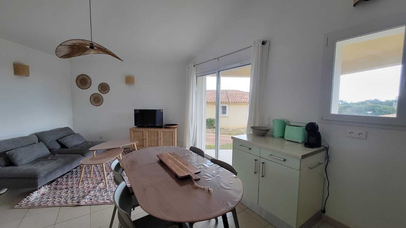 Een moderne woonkamer met een bank, een eettafel en een televisie.