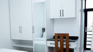 Une chambre moderne avec un lit, un bureau et une armoire.