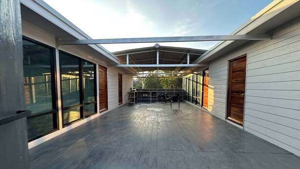 A covered outdoor area with a wooden deck, large windows, and a view of the surrounding landscape. - #4 - Private Villa 2BR 1000mbps Wi-fi (Ko Pha-ngan)
