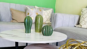 A round white table with three green vases and a gold spherical object.