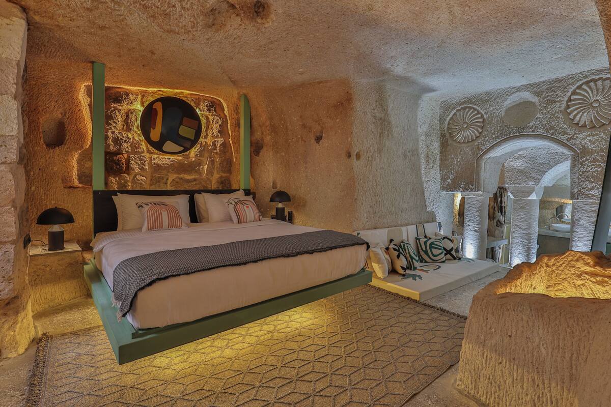 Ein Schlafzimmer mit einem Bett, einem Nachttisch, einer Lampe und einer Wand mit einem runden Dekor.