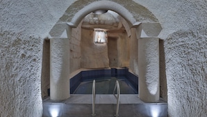 A stone-walled pool with metal ladders, a small window, and a tiled floor. - EKA CAVE MAISON (Ürgüp)
