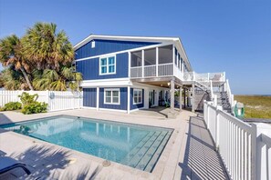 Enjoy a beachfront retreat with a spacious balcony, covered outdoor area, and a swimming pool.