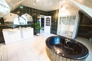 A modern bathroom with a large black bathtub, two white sinks, and a glass shower enclosure. - Villa in Brenna Near Ski Lifts (Brenna)