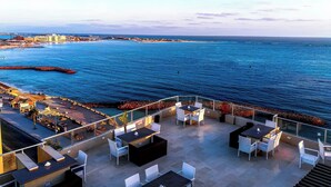 A rooftop terrace with outdoor seating, overlooking a coastal cityscape and the sea. - Luxury Apartment 3BR & Full Sea View (Marsa Matrouh)