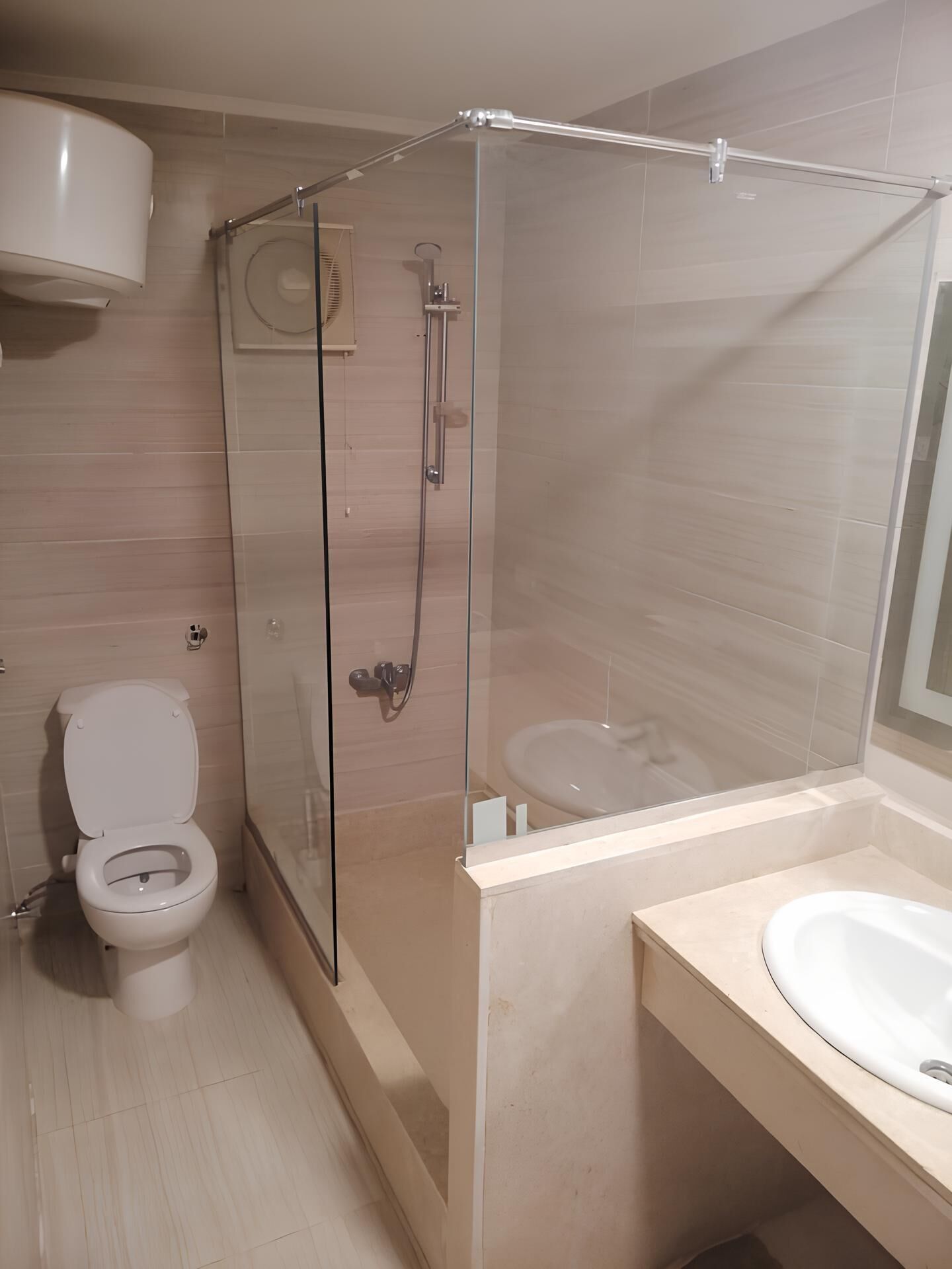 Une salle de bain moderne avec une douche à parois de verre, des toilettes et un lavabo.
