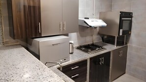 A modern kitchen with a built-in oven, stainless steel appliances, and granite countertops. - Luxury Apartment 3BR & Full Sea View (Marsa Matrouh)