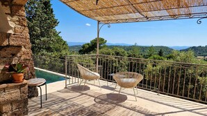 A balcony with a pool, wicker chairs, and a view of the countryside. - Charming family villa in Tourtour. 40 minutes from the Côte d'Azur. (Tourtour)