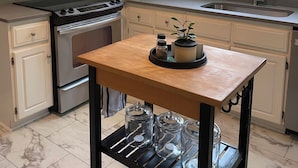 A kitchen with white cabinets, a stainless steel microwave, a stove, a sink, and a window with a view of trees. - Welcome to Augusta. This beautiful and home has lots of Southern Charm. (Augusta)