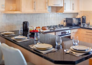 Enjoy cooking and dining in this well-equipped kitchen with a central island, gas stove, and microwave.