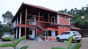 A two-story building with a red and white exterior, a covered porch, and a staircase leading to the upper floor.