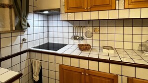Cozinha com armários de madeira, painel de azulejos e fogão preto.