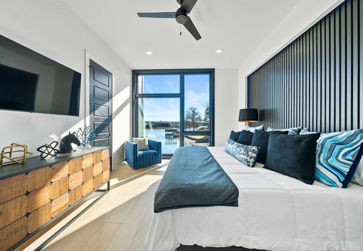 Een moderne slaapkamer met een bed, een bureau, een stoel en uitzicht op het buiten.