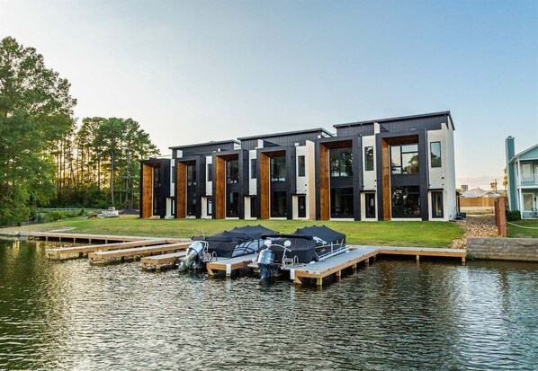 A modern multi-story building with a dock and boats.