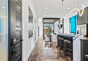 A modern kitchen with a marble countertop, a large window, and a view of the outdoors.