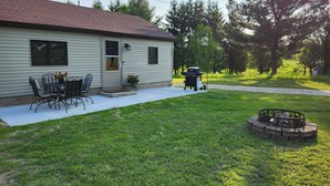 A residential house with a patio, a barbecue grill, and a fire pit.