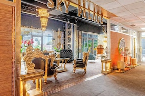 Experience the grandeur of this lavish space, featuring a chandelier, ornate furniture, and a large mirror.