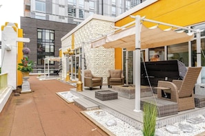 Relax and socialize in this outdoor patio area with a sofa, armchairs, and grill.