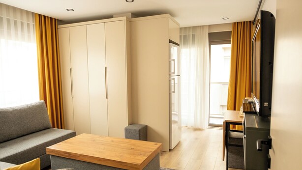 Una sala de estar moderna con sofá, mesa de centro y televisor en la pared.