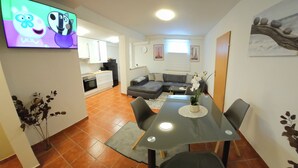 A modern living space with a dining area, kitchen, and a cozy seating area.