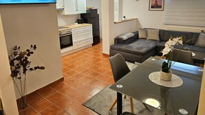 A modern living space with a kitchen, dining area, and seating area.