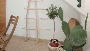 Eine Treppe mit Blumentöpfen, einem Holzstuhl und einer Leiter.