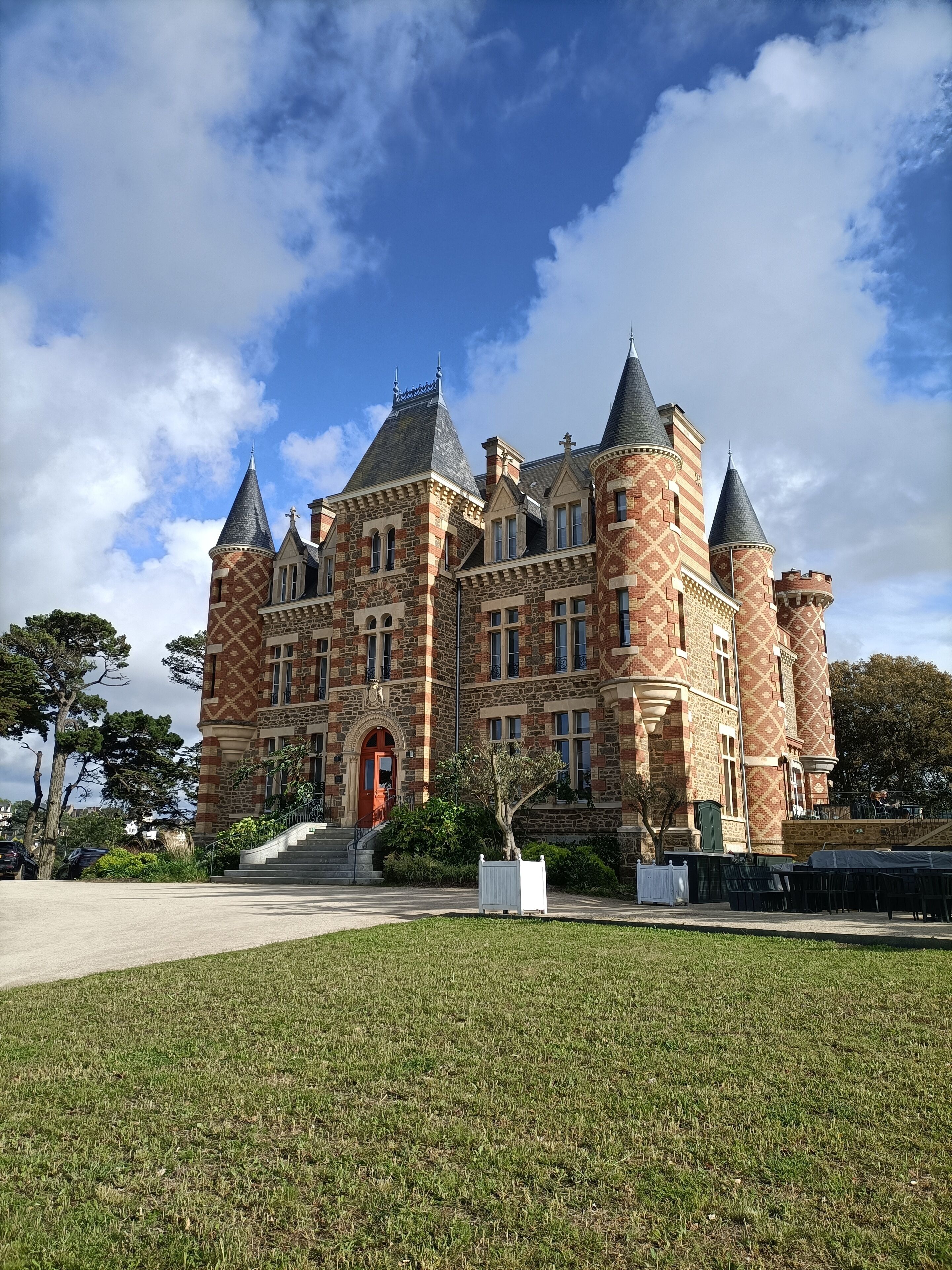 Un grand bâtiment historique doté de nombreuses tours et d’une entrée centrale.