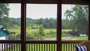 Una habitación con vistas a un río y vegetación.