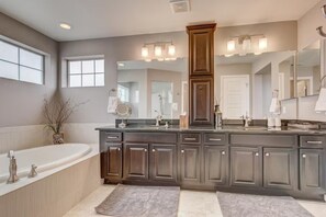 A modern bathroom with a large vanity, a freestanding bathtub, and a large mirror. - 5400sqft 6BR 5.5BA Theater, Office, Game Room // 10min to DIA & Downtown (Denver)