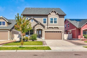 A two-story house with a garage, a small front yard, and a driveway. - 5400sqft 6BR 5.5BA Theater, Office, Game Room // 10min to DIA & Downtown (Denver)