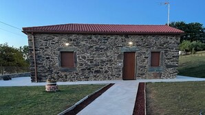 Edifici de pedra amb teulada vermella, dues portes de fusta i un petit finestral a cada banda.