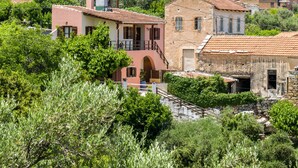A hillside village with traditional stone buildings, some with balconies and arched doorways. - COZY VILLA ZOI (Tzitzifes)