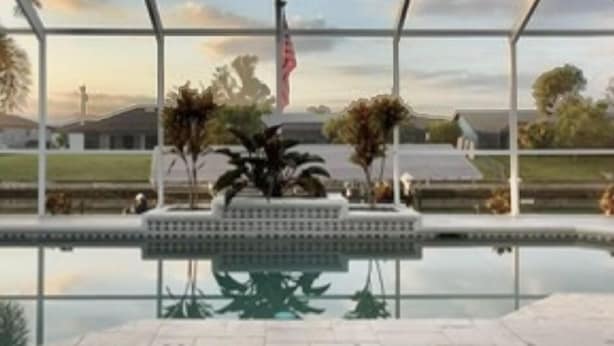 A pool area with lounge chairs and a small dog.