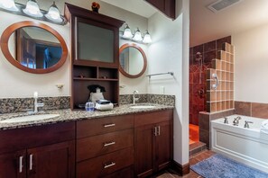 A bathroom with two sinks, a large mirror, and a shower area. - Luxury Pigeon Forge Condo  Near Dollywood & Parks (Pigeon Forge)