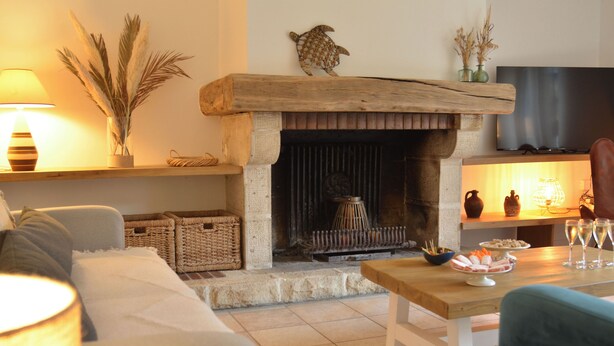 A cozy living room with a fireplace, a sofa, a coffee table, and a TV.