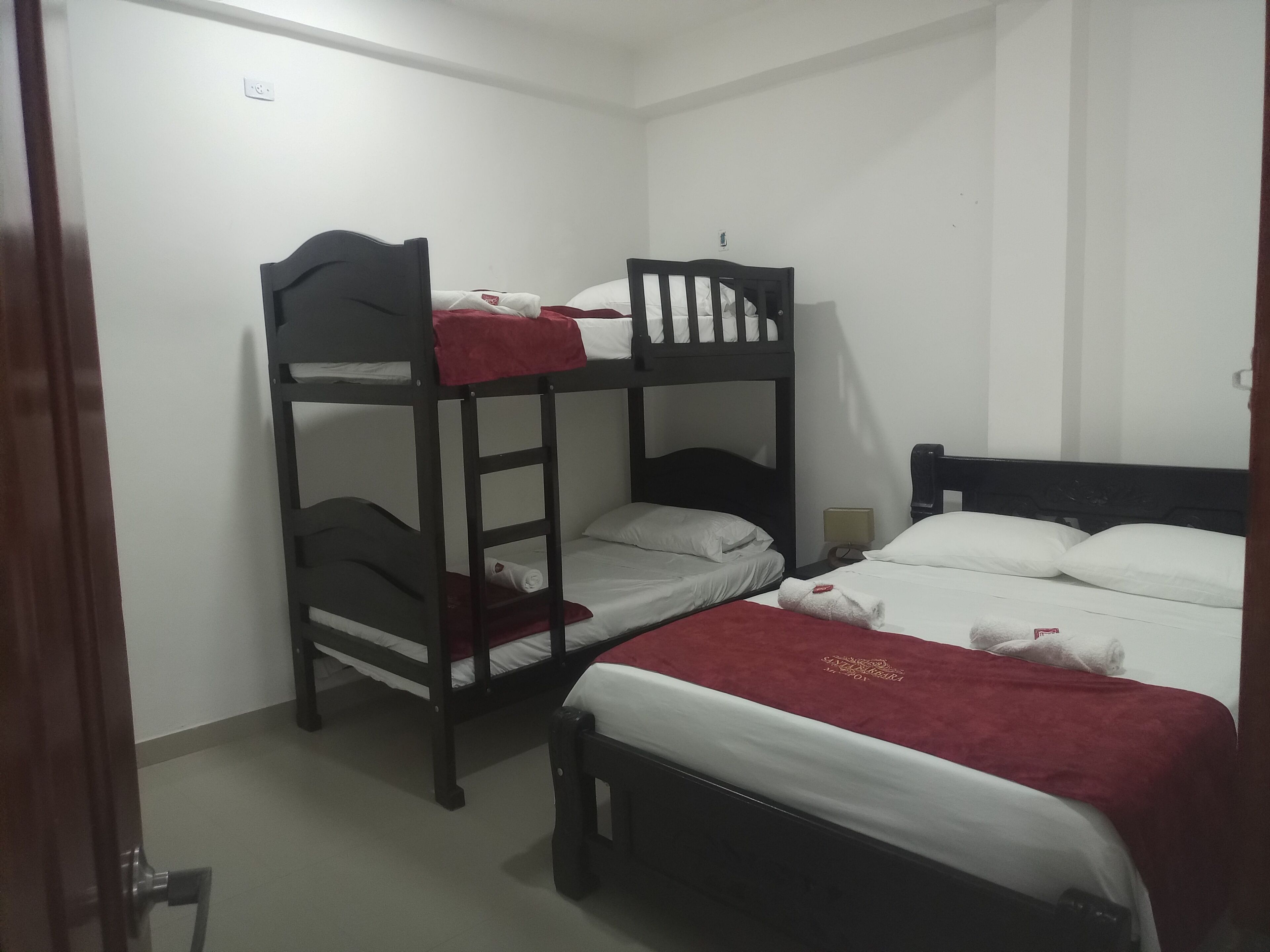 Ein Schlafsaalzimmer mit Etagenbetten, einem Nachttisch und einem Beistelltisch.