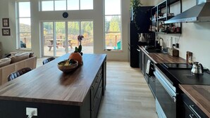 Una cocina moderna con una isla central, ventanas amplias y vistas al exterior.