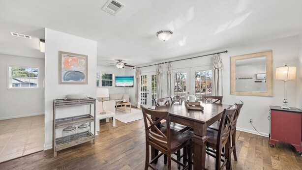Un salón espacioso con una mesa de comedor de madera, asientos cómodos y un amplio ventanal con vistas al exterior.