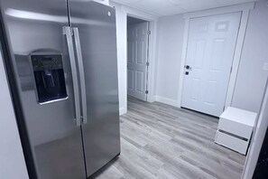A kitchen with a stainless steel refrigerator, a water dispenser, and a white cabinet.