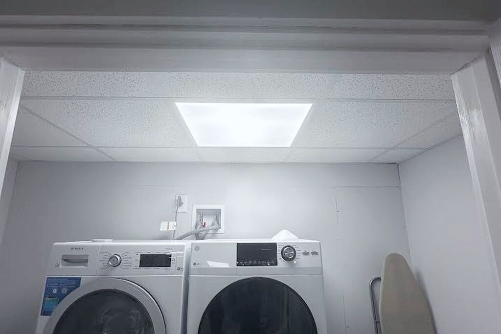 A laundry room with two front-loading washing machines and a dryer.