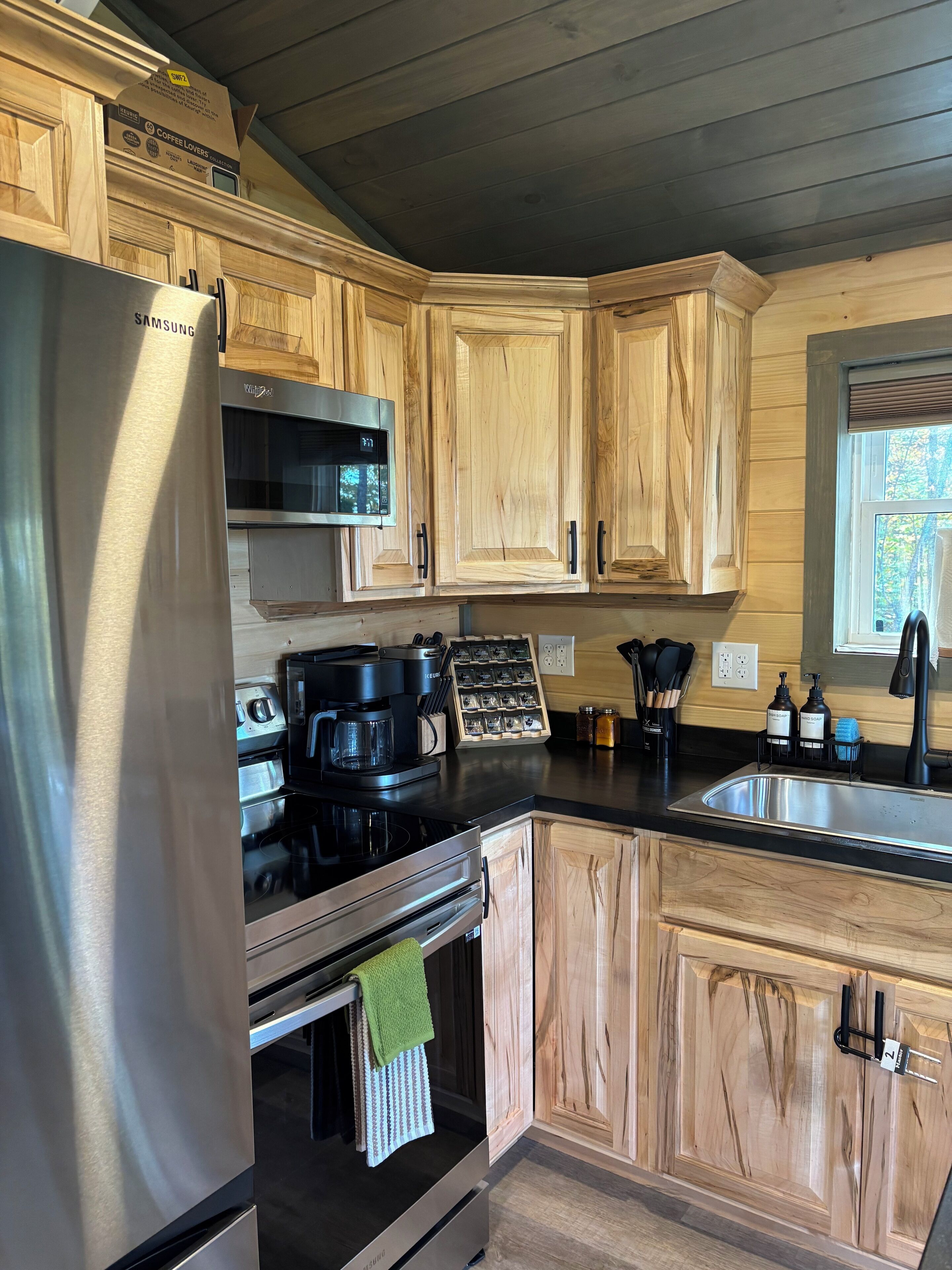 A modern kitchen with wooden cabinets, stainless steel appliances, and a built-in oven.