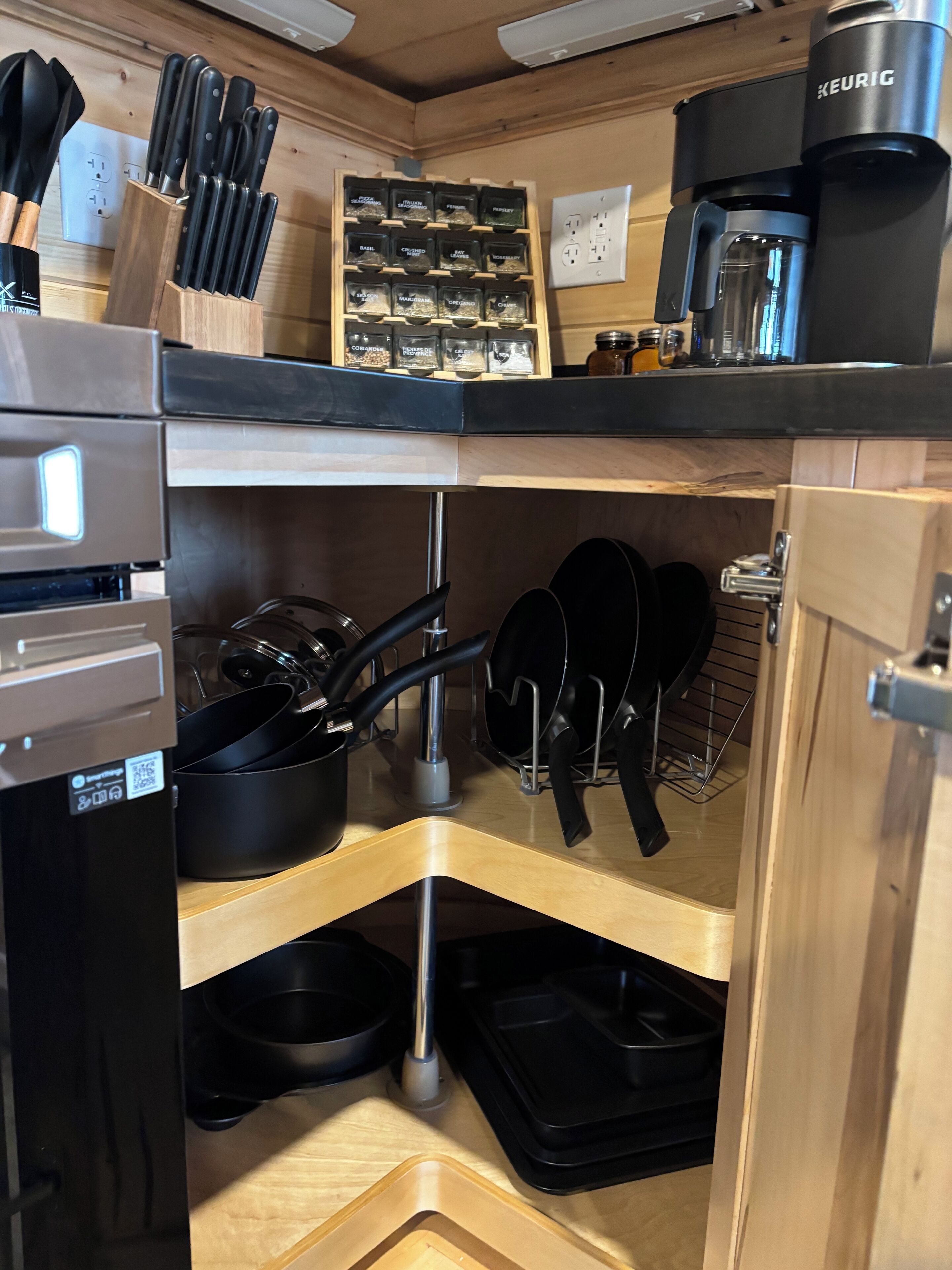 Una cuina amb forn integrat, cafetera i prestatge per a espècies.