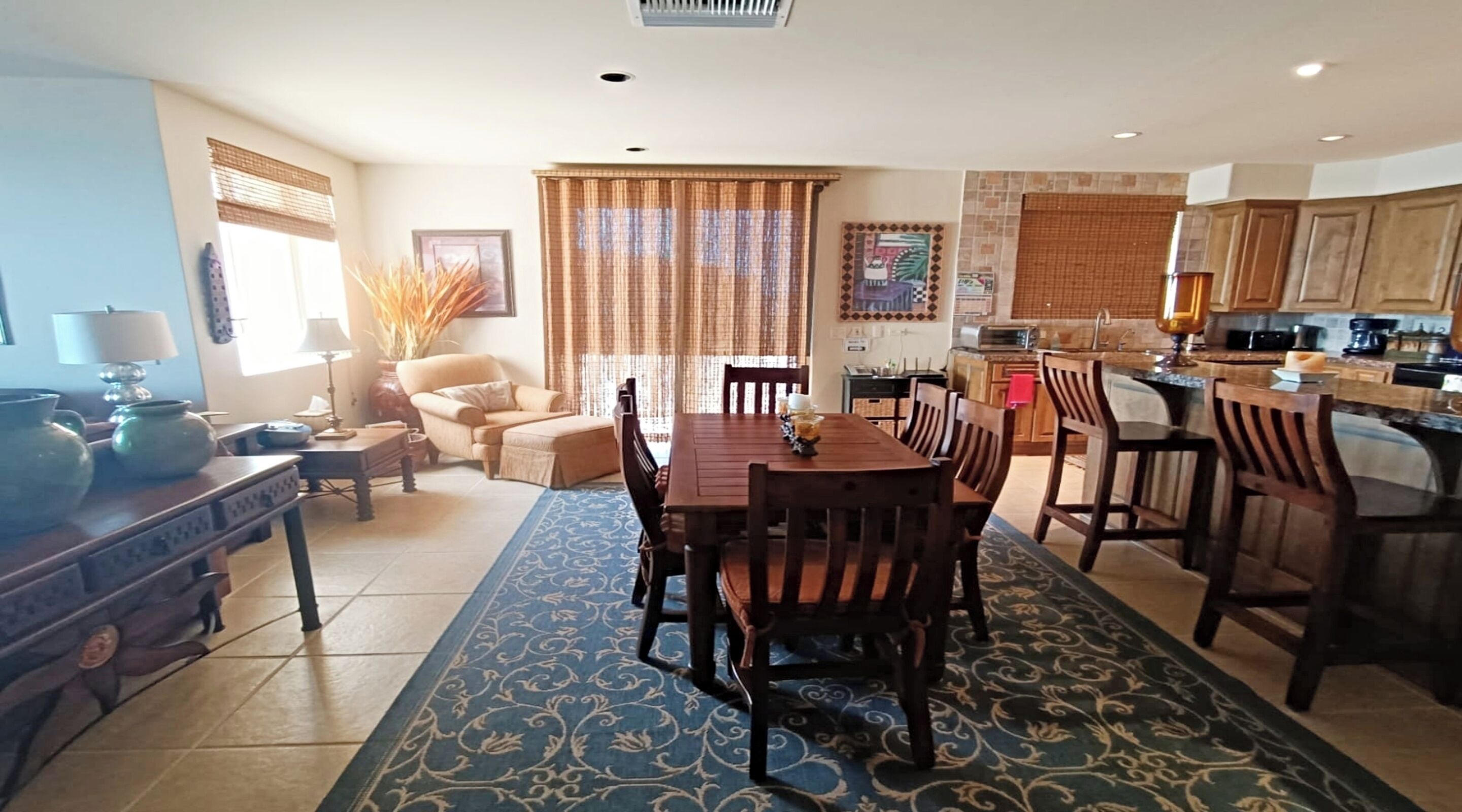 Amplia sala de estar con una mesa de comedor, sofás y una cocina al fondo.
