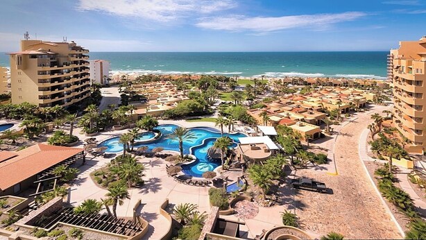 A resort with a large central pool, beachfront villas, and a view of the ocean. - Condo Bella Sirena 805 C by Kivoya (Puerto Peñasco)