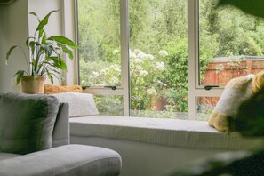 Una zona d'estar acollidora amb una banca amb coixí i una planta en test.