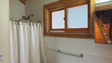 Een douche, handdoeken, zeep, toiletpapier